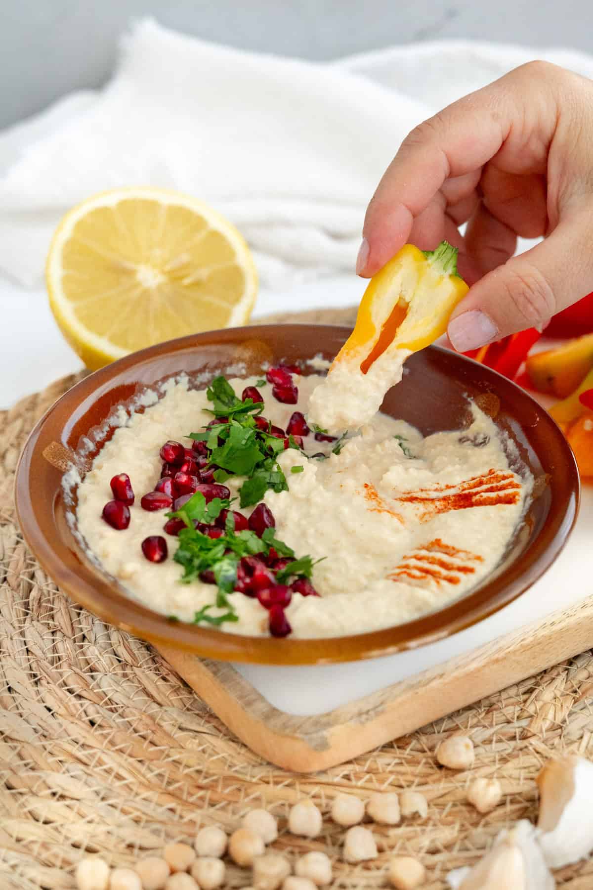 một bàn tay nhúng một crudite vào hummus