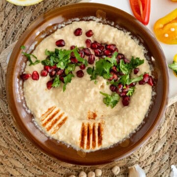 một đĩa cối và chày đựng hummus