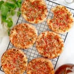 a cooling rack with tomato and onion manakeesh on it