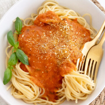 cherry tomato spaghetti sauce in a bowl on top of spaghetti