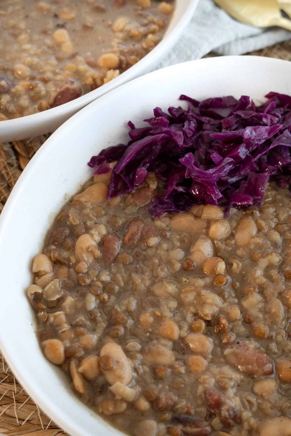 a bowl of bean grain stew with pickled cabbage 