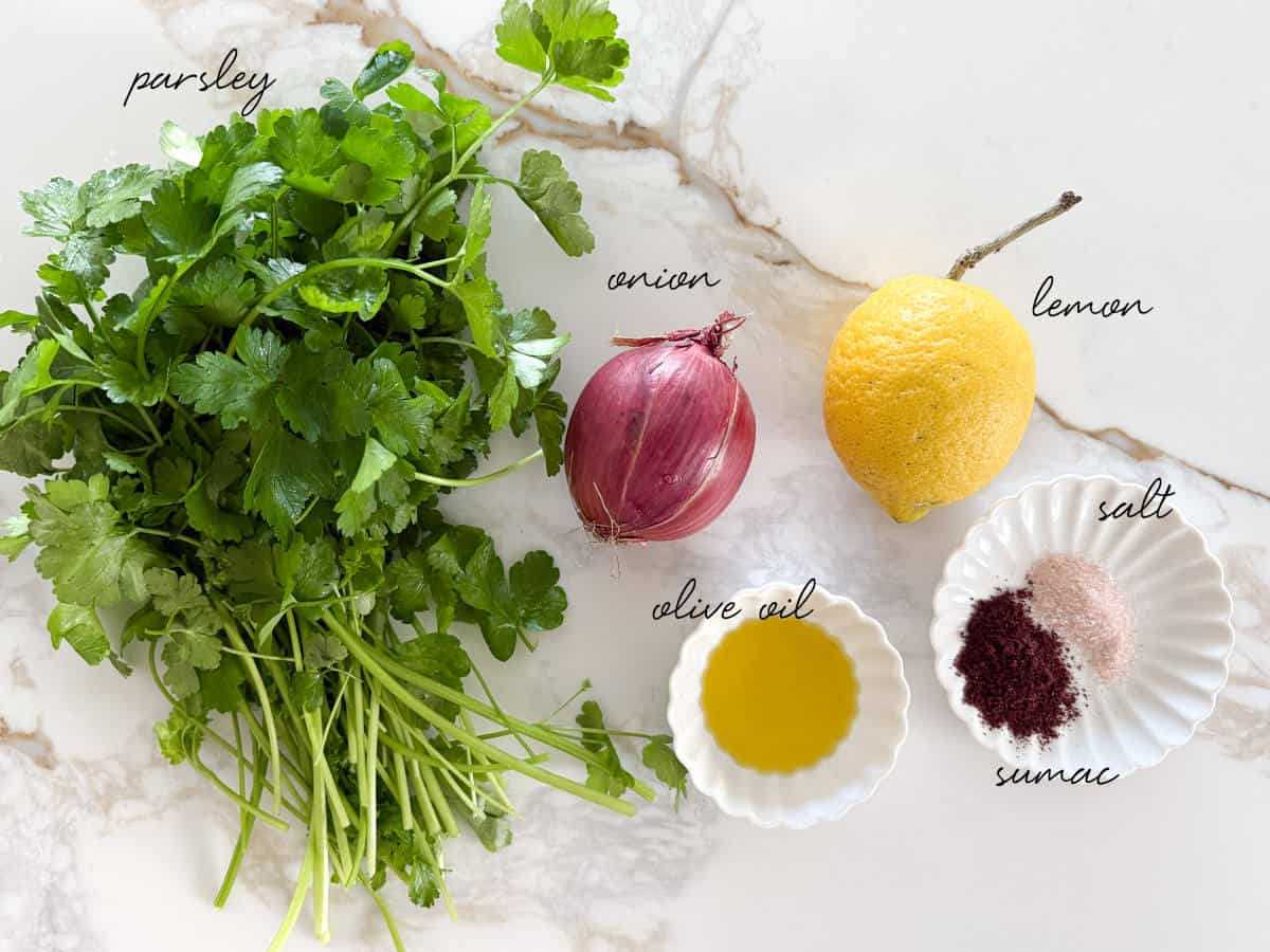 parsley, onion, lemon, oil and spices laid out in bowls