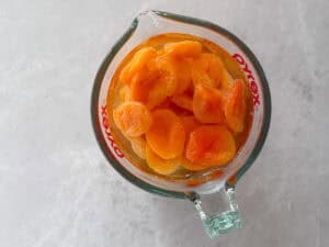 dried apricots soaking in water in a jug