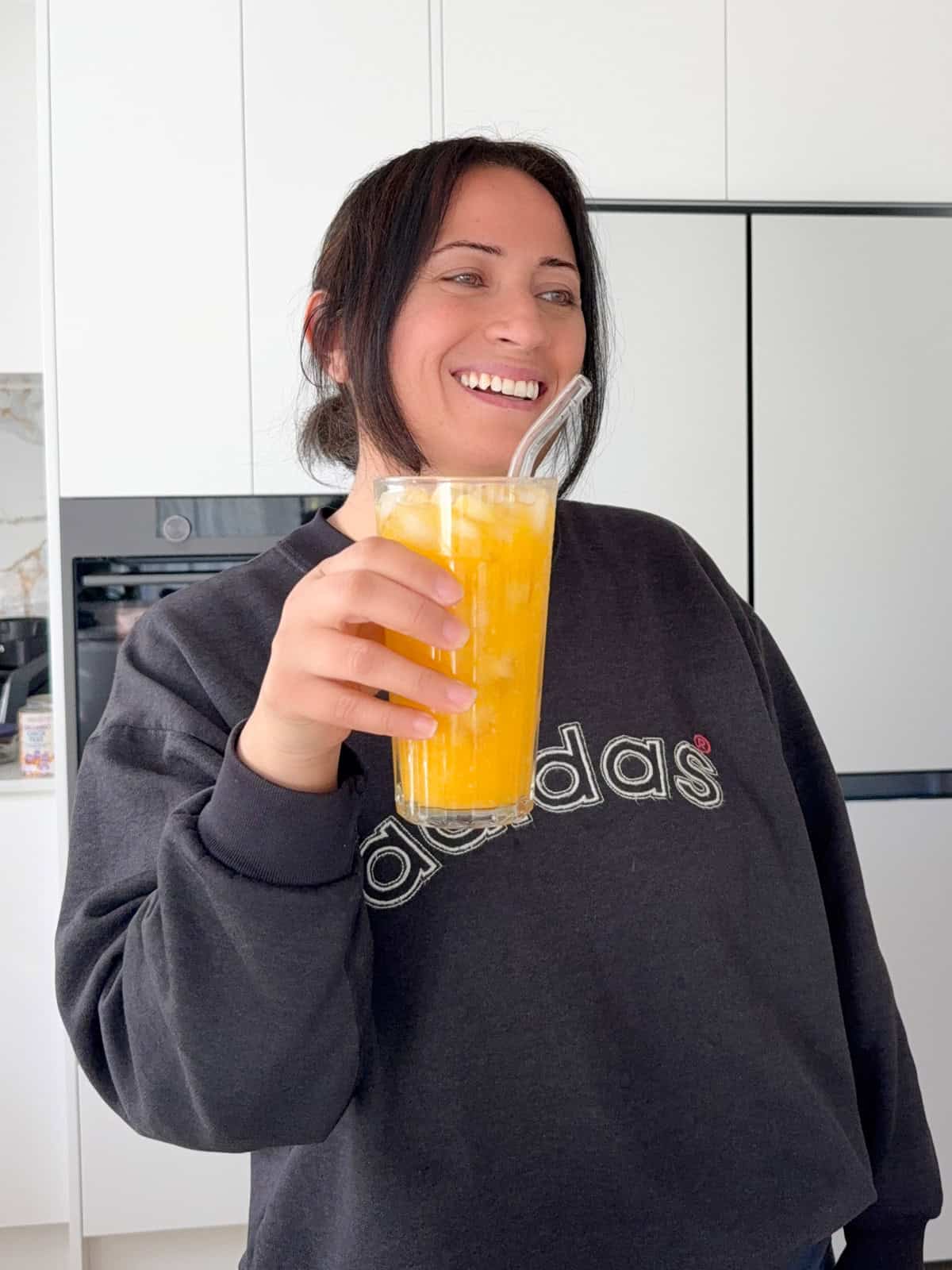 janelle hama holding a glass of apricot juice