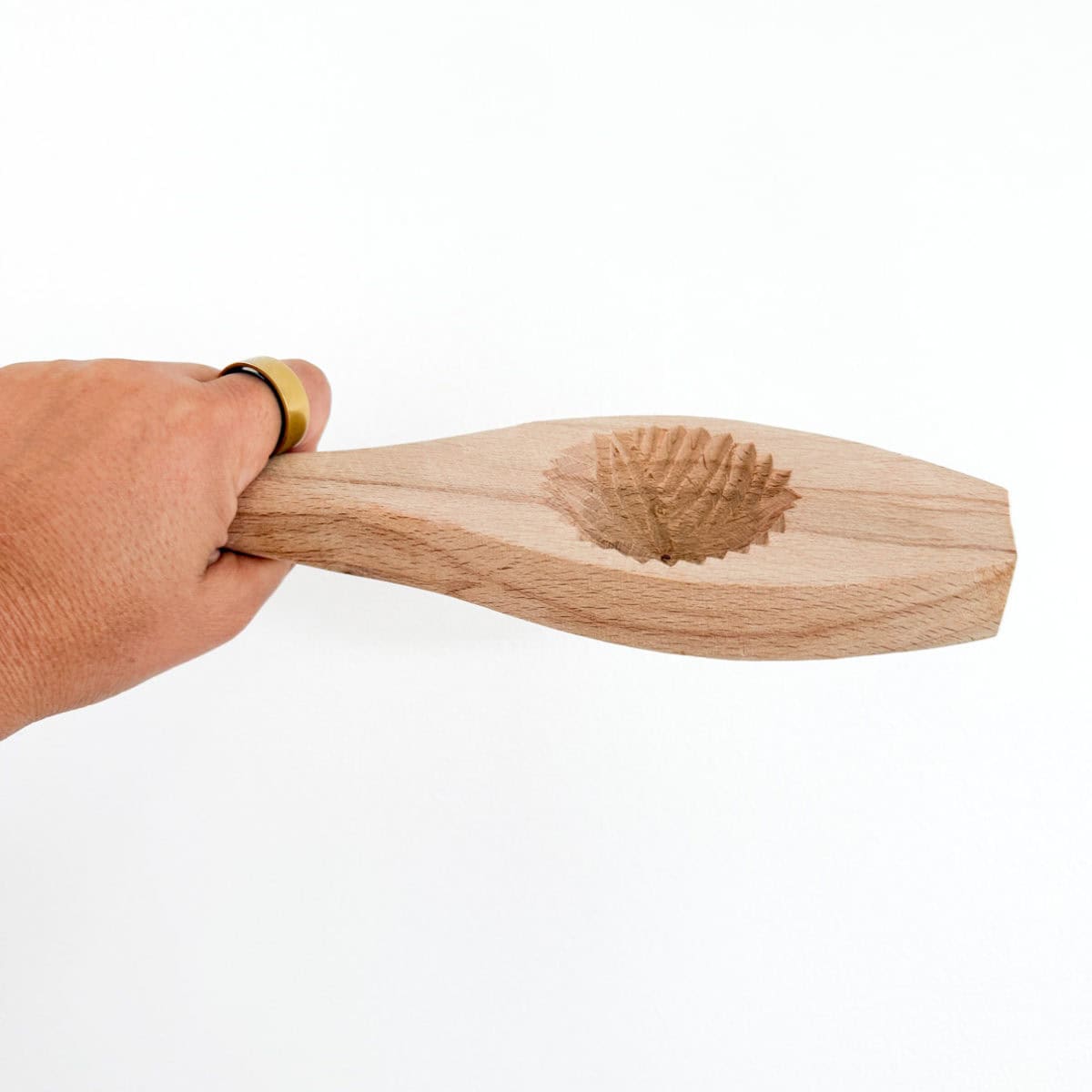 pistachio maamoul mold held in a hand