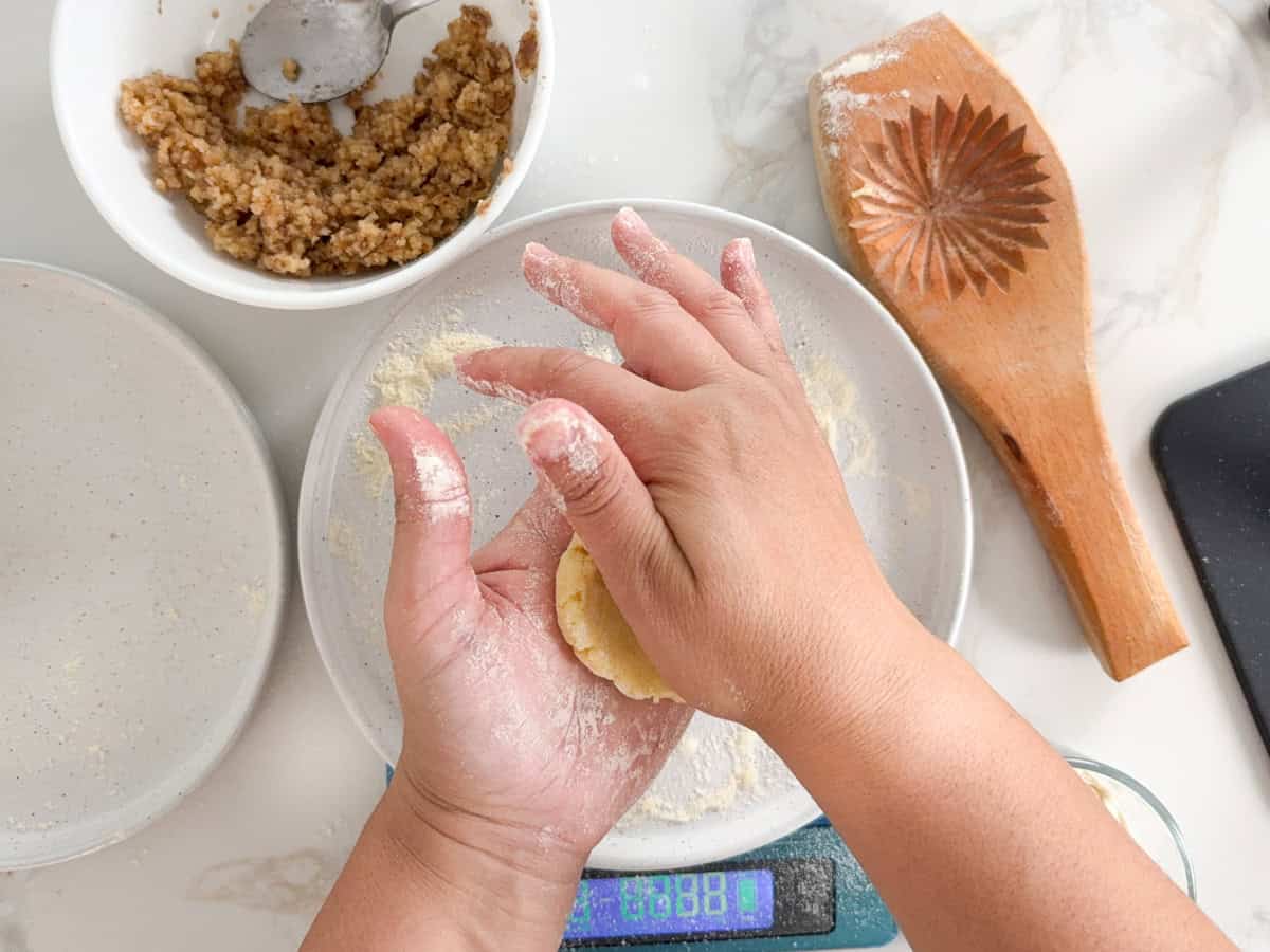 hands flattening maamoul dough