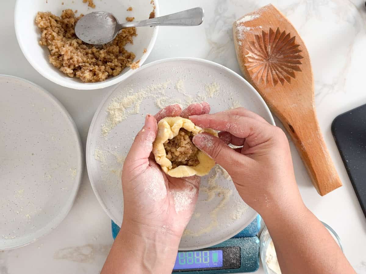 closing the walnut filling with maamoul dough