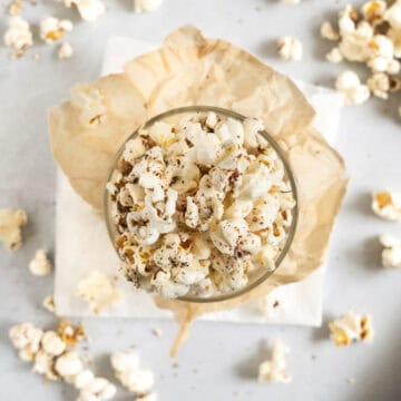 zaatar popcorn in a cup with spilled popcorn on the sides