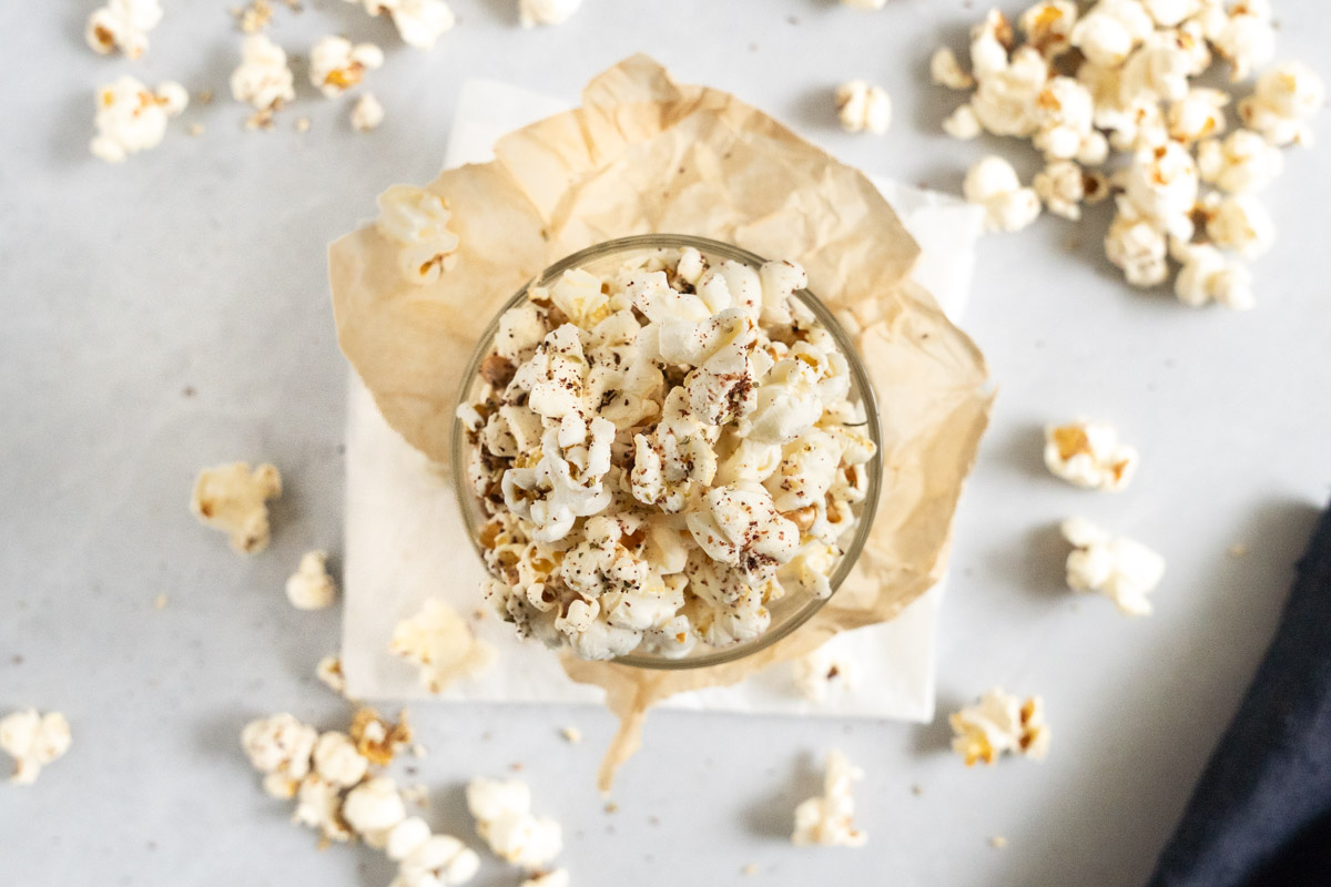 zaatar popcorn in a cup with spilled popcorn on the sides