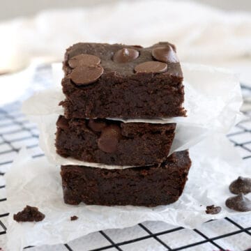 a stack of chickpea brownies with paper in between each brownie
