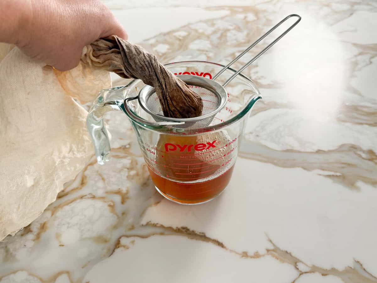 tamarind pulp strained through a cloth into a glass jug