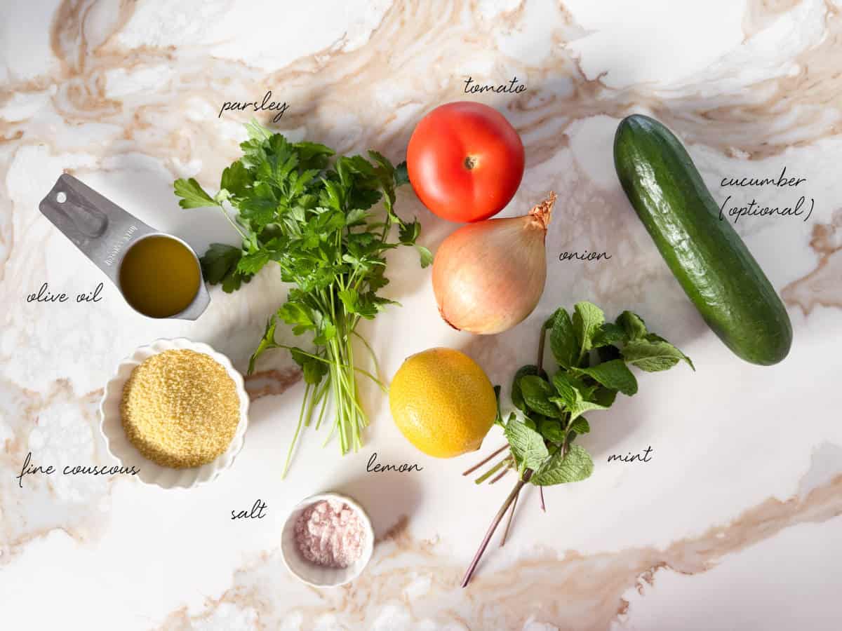 couscous, oil, lemon, parsley, tomato, cucumber, onion, and salt laid out