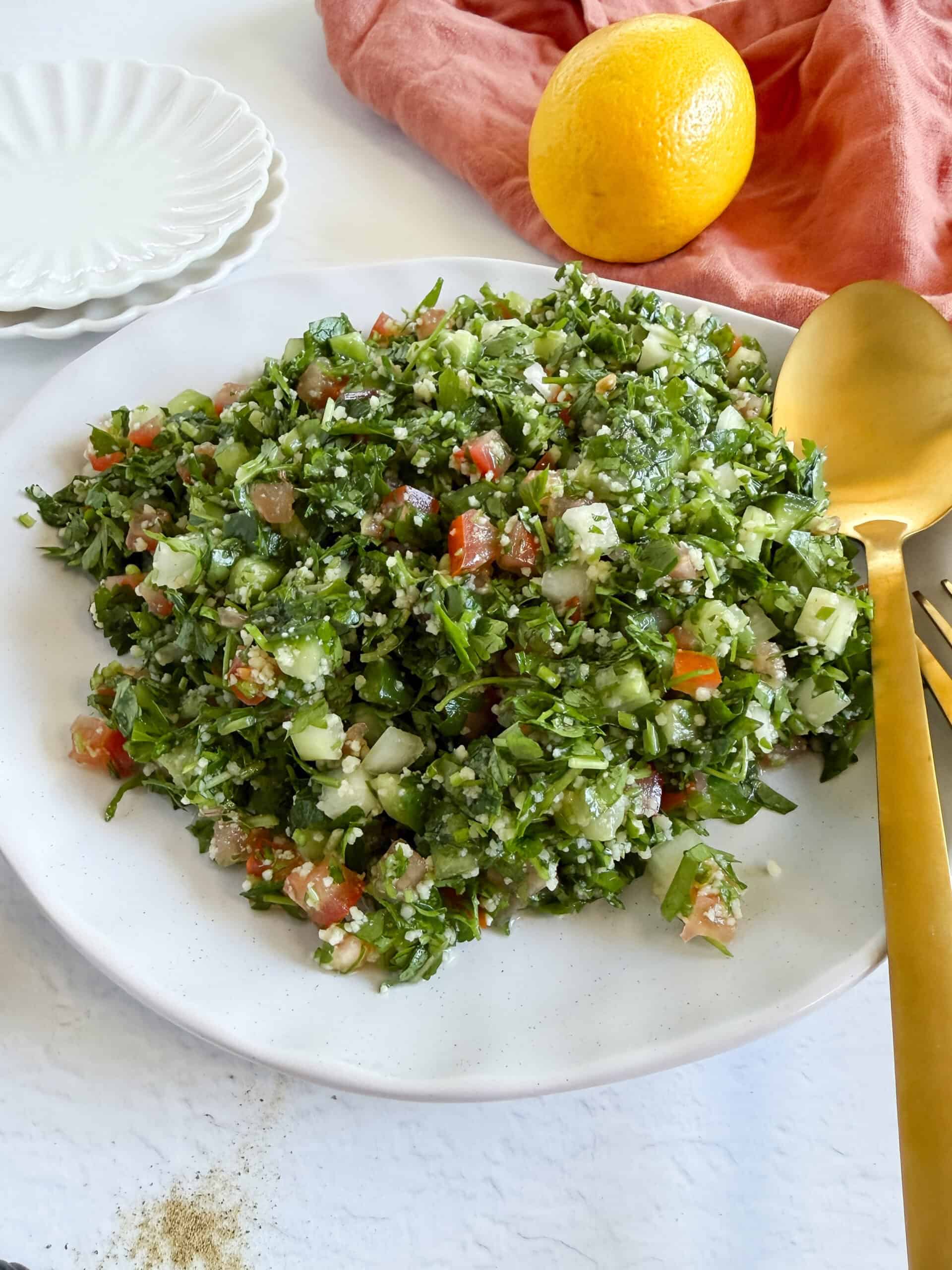 a heap of couscous tabbouleh in a plate with cutlery