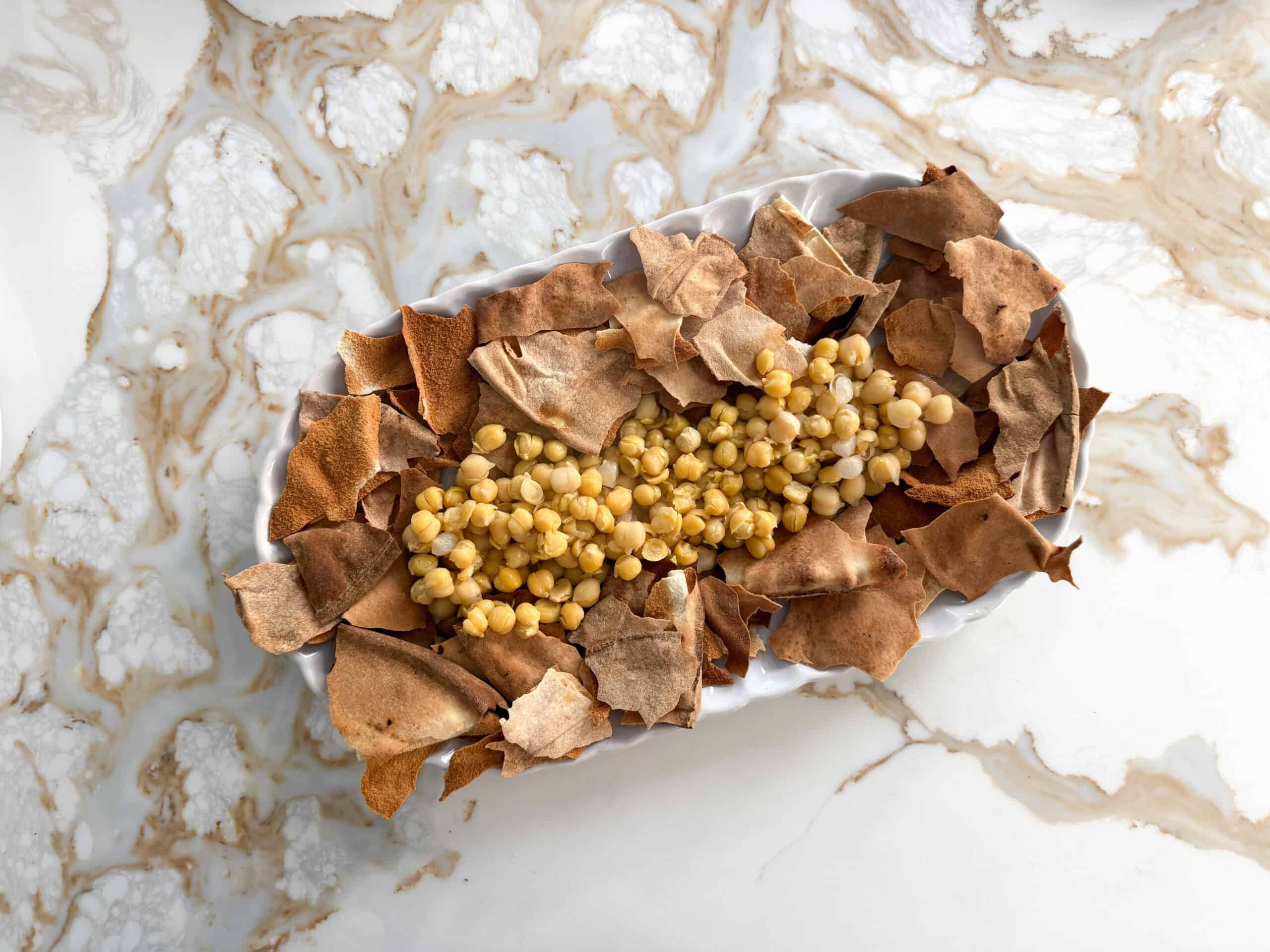 crispy broken pita bread with chickpeas on a white plate