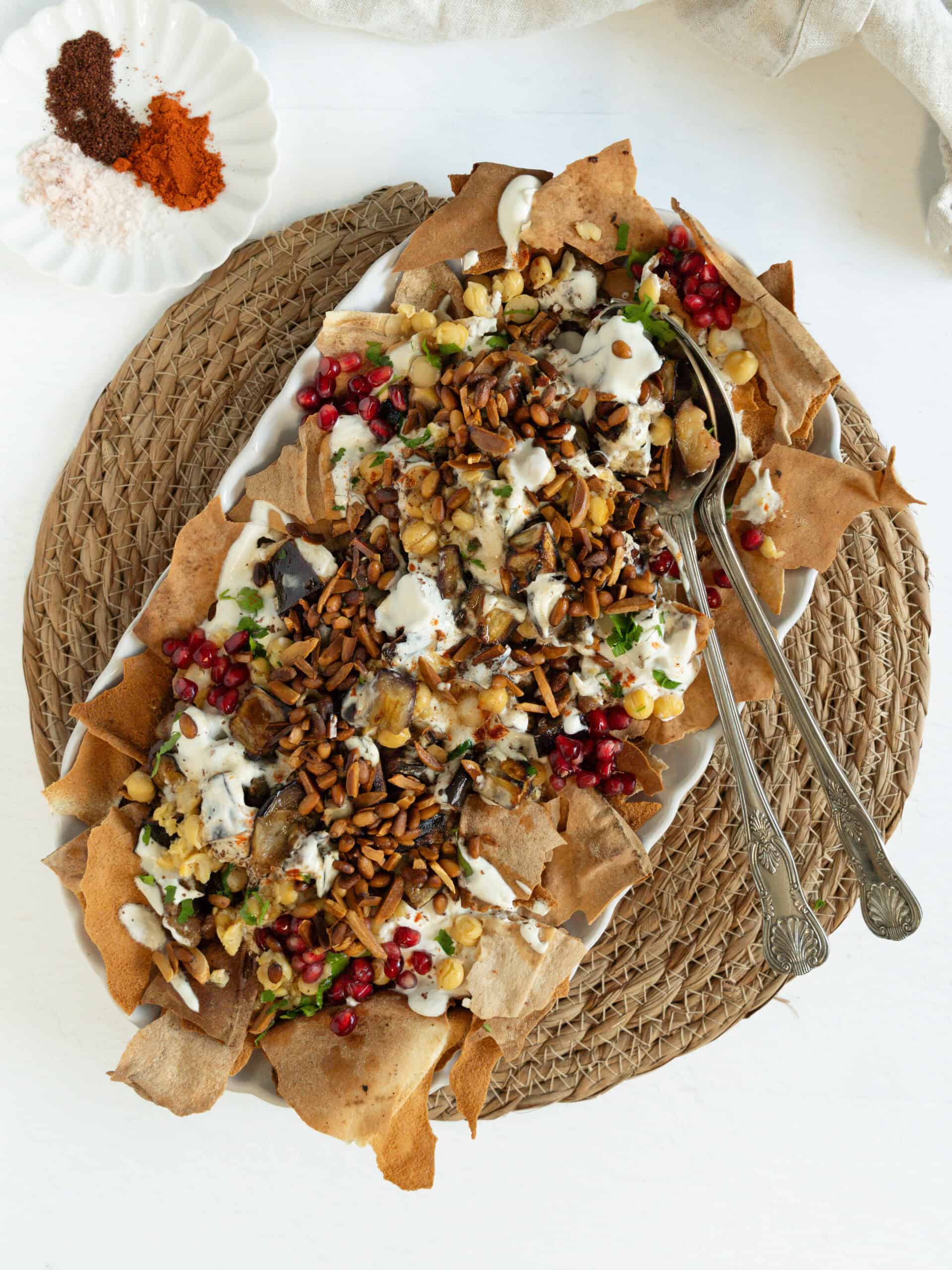 Vegetarian Eggplant Fatteh topped with nuts and pomegranate seeds.