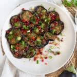fried eggplant slices topped with dressing chopped herbs and chili