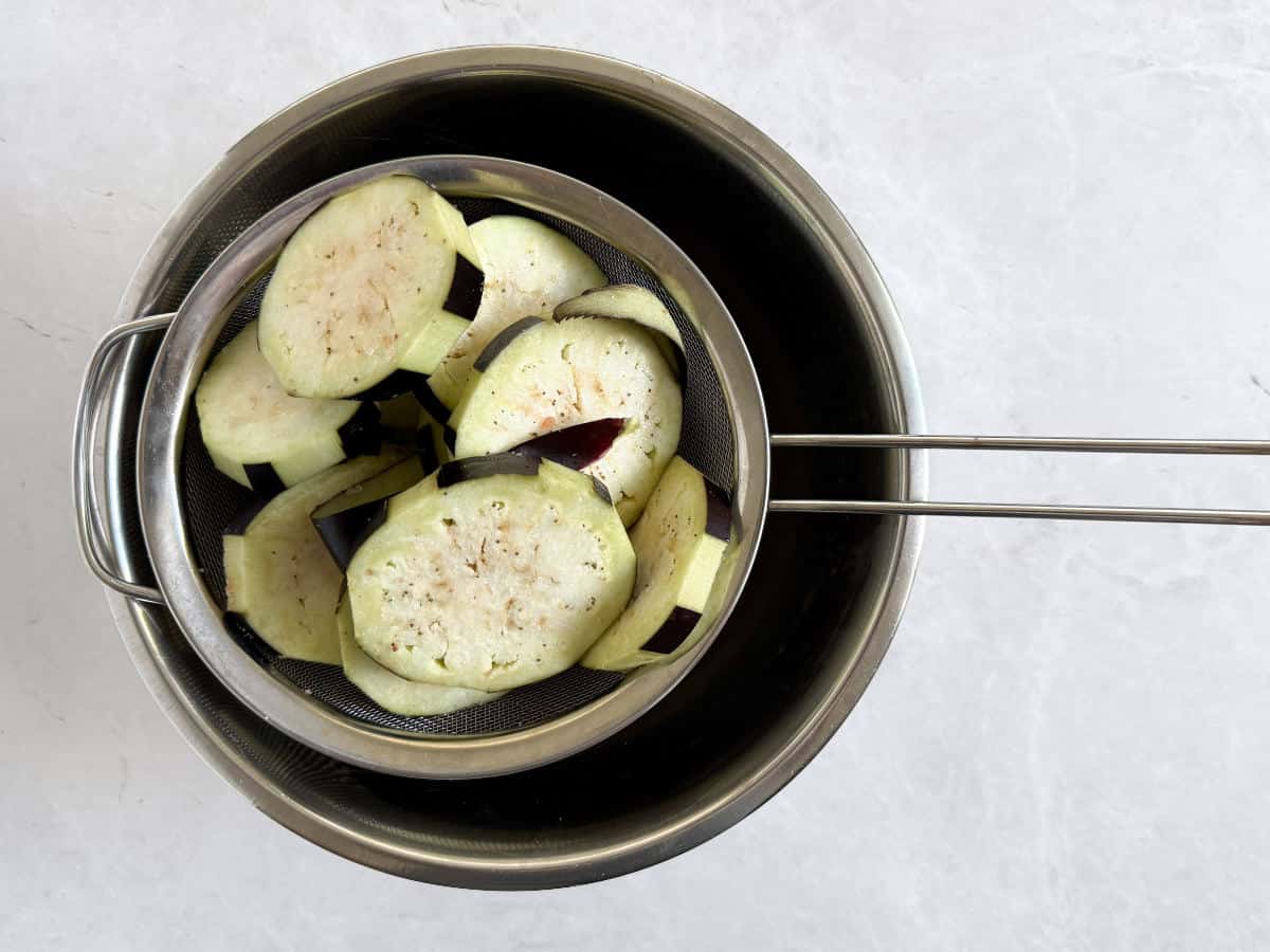 slices of eggplant in a colander
