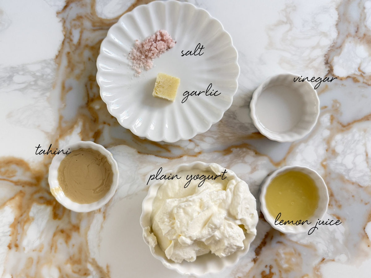 yogurt, tahini, vinegar, lemon juice, garlic and salt laid out in bowls