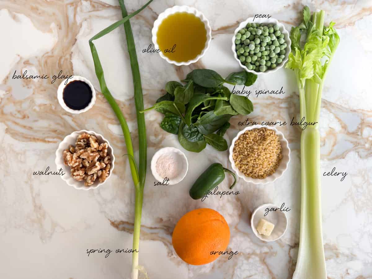bulgur, spinach, oil, peas, celery, balsamic glaze, salt, jalapeno, lemon, garlic and walnuts laid out