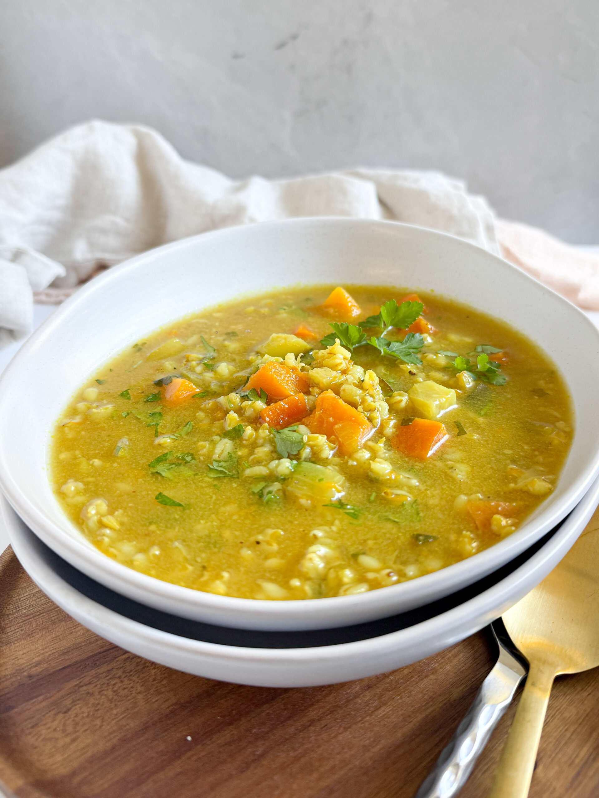 veggie barley soup in a white bowl