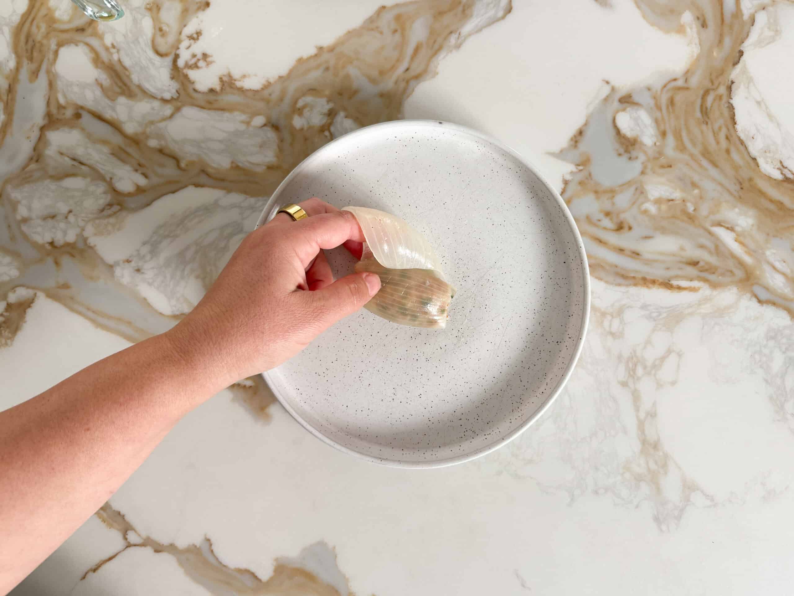 rolling a boiled onion layer with rice inside it