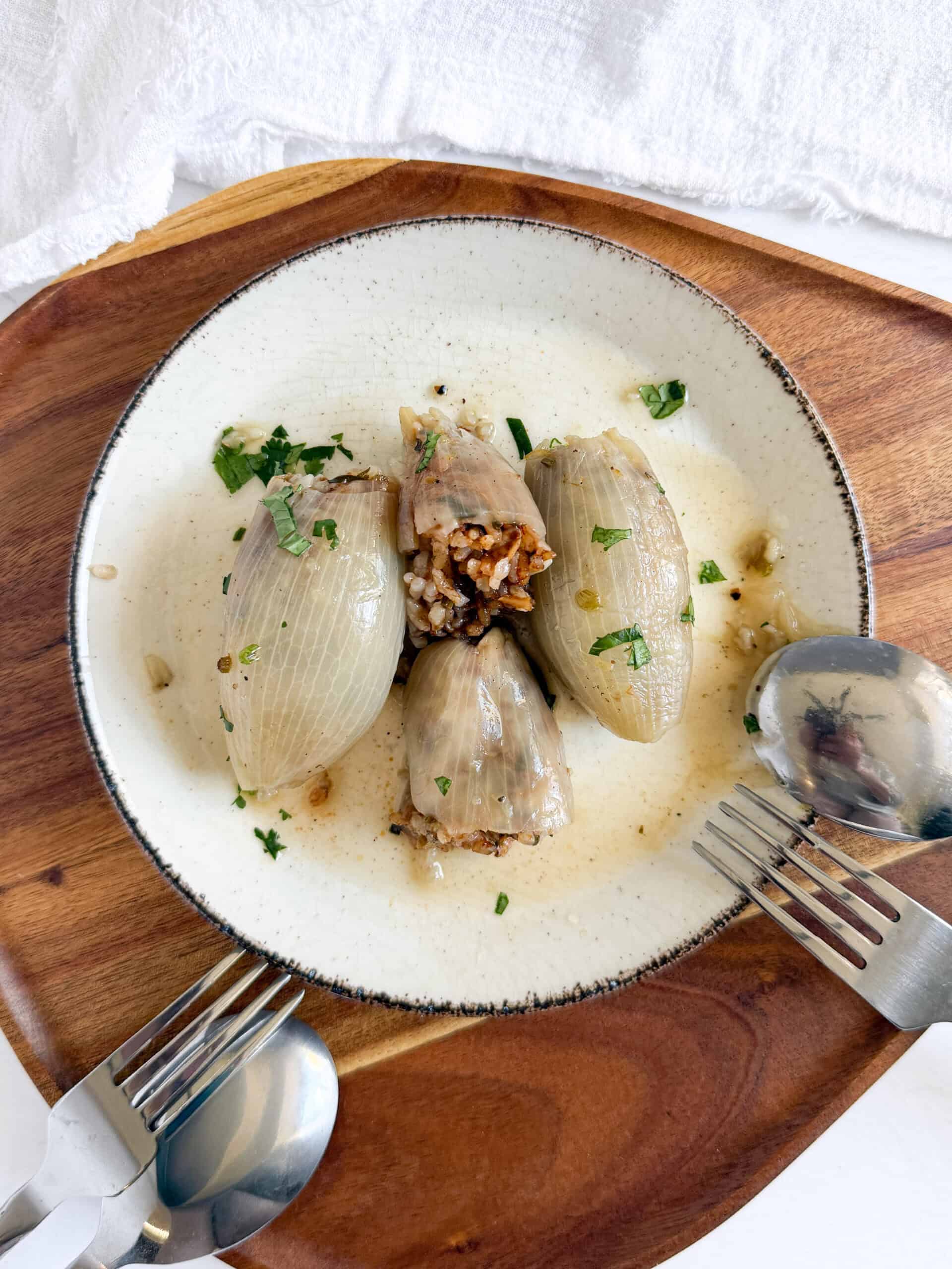 stuffed onions with rice coming out of one in a plate